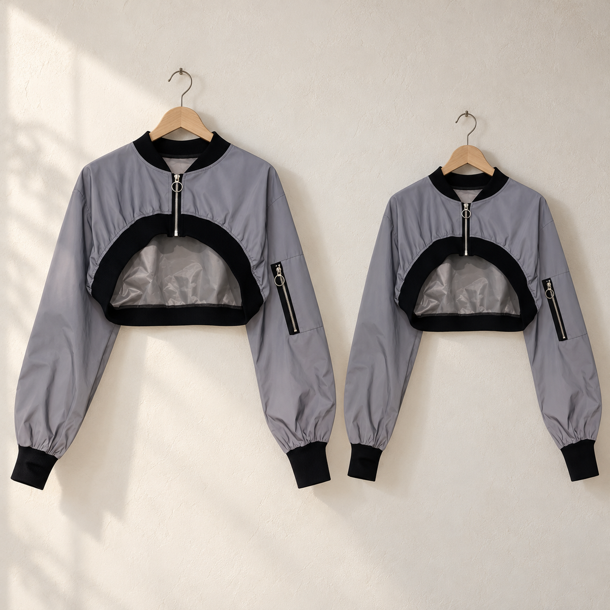 Dos chaquetas crop grises completas con remates negros.